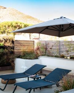 two picnic tables and an umbrella on a patio at Domìa Boutique Hotel e Cucina in Mondello