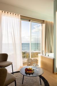 a living room with a table and a view of the ocean at Metamare in Cozze