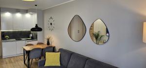 a living room with a couch and two mirrors on the wall at APARTAMENT MARZENA in Świnoujście