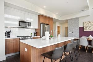a kitchen with a white counter top and wooden cabinets at 2880 Skyline Penthouse at Espadin in Denver