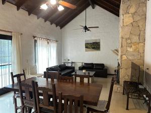 - une salle à manger et un salon avec une table en bois dans l'établissement Casa en Carilo con Pileta, Quincho y Parque Cercado para 8 Personas, à Carilo