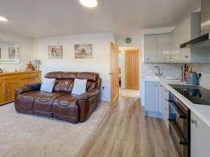 a living room with a leather couch in a kitchen at Priscilla Close 1 Bedroom in Earlham