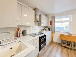 a kitchen with white cabinets and a sink at Priscilla Close 1 Bedroom in Earlham +4 photos