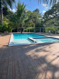 a large swimming pool in a yard with trees at Hotel Colonial in Cajati +16 photos