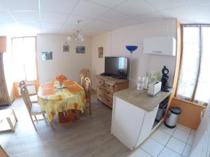 a kitchen and dining room with a table and a television at Les cascades in Le Mont-Dore