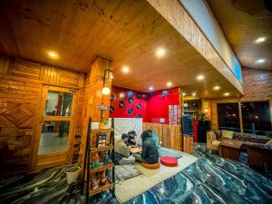 deux personnes assises sur le sol d'une pièce dans l'établissement The Elevia, Jibhi, à Jibhi 49 autres photos