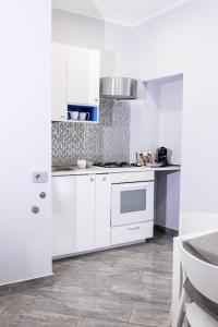 a kitchen with white cabinets and a stove at Little House AURORA in Melfi +9 photos