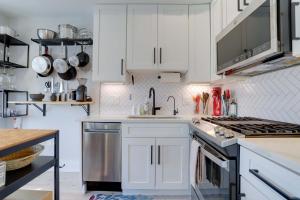 ワシントンにあるSojourn Condo in NW DC 2 blocks to Shaw Metroの白いキャビネットとシンクのあるキッチン