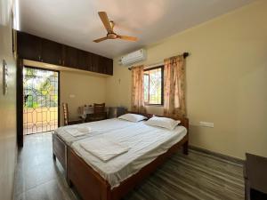een slaapkamer met een bed en een plafondventilator bij D 'SOUZA HOLIDAY HOME in Benaulim +52 foto's