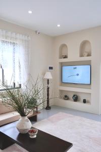 Una sala de estar con un televisor en la pared. en Panacea The Villa, en Mộc Châu