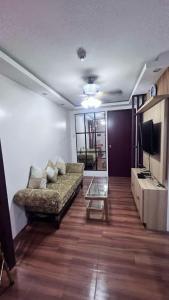 a living room with a couch and a tv at Manila Condo Staycation in Manila