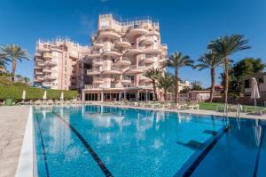 een hotel met een zwembad voor een gebouw bij Magical Sea View with 3 Bedroom in Eilat