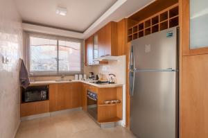 una cocina con nevera de acero inoxidable y armarios de madera en Magical Sea View with 3 Bedroom, en Eilat