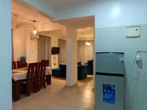 a kitchen and dining room with a refrigerator in a room at Noni's Place, Greenwood Gardens, Mtwapa in Mtwapa