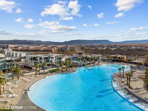 ein großer Swimmingpool mit Palmen und Gebäuden in der Unterkunft Simply BeUTAHful at Desert Color (by Ember Stays) in Atkinville