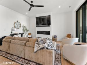 ein Wohnzimmer mit einer Couch und einer Uhr an der Wand in der Unterkunft Simply BeUTAHful at Desert Color (by Ember Stays) in Atkinville