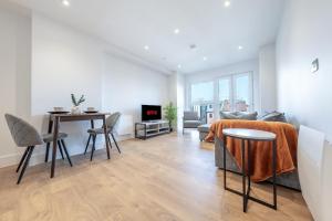 una sala de estar con un sofá y una mesa en ZAI Stays- LutonTown NEWModern 2bed flat, en Luton