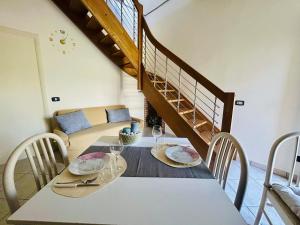 a dining room with a table with chairs and a staircase at La Dimora nel Cilento in Omignano