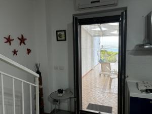 a door leading to a patio with a chair at Sunsea House Copanello in Copanello
