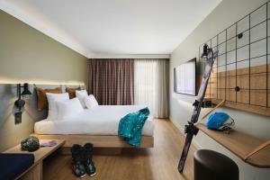 a hotel room with a bed and a desk at Moxy Annecy in Annecy