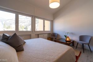a bedroom with a large bed and two windows at Varenna My Love in Varenna