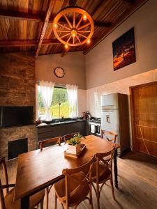a kitchen with a wooden dining room table and chairs at Cabana Montana Viva Cada Momento in Guaramirim