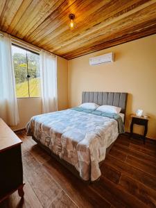 a bedroom with a large bed with a wooden ceiling at Cabana Montana Viva Cada Momento in Guaramirim