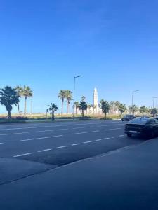 una calle con coches aparcados al costado de la carretera en Appartement sur bd la corniche luxury house with garden close to beach, en Casablanca
