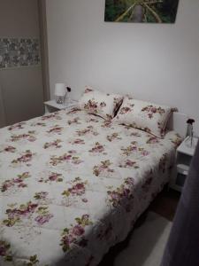 Una cama con un edredón floral en un dormitorio. en Appartement sur bd la corniche luxury house with garden close to beach, en Casablanca