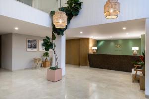 una hall con reception e piante in vaso di Hotel MS Ciudad Jardin a Cali