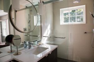 a bathroom with a sink and a shower with a mirror at North Harbor Montauk in Montauk +10 photos