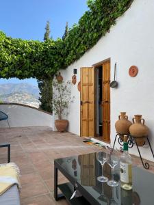 a patio with a table and wine glasses at Casita with Views of Frigiliana in Frigiliana