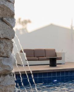 Eine Couch steht auf einer Terrasse neben einem Pool. in der Unterkunft Hotel Nikché Mérida in Mérida