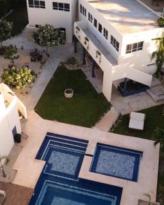 an aerial view of a building with two swimming pools at Hotel Nikché Mérida in Mérida