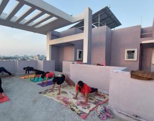 a group of people doing yoga on the roof of a house at Yoga Retreat Wellness by Atulyam in Lucknow