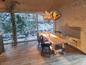 a dining room with a wooden table and chairs at 4 Strony Lasu in Gołaczów