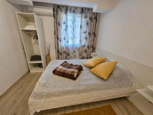 Un dormitorio con una cama con dos almohadas y una ventana. en Данделион, en Burgas