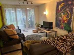 a living room with a couch and a television at House Apartment am See in Markkleeberg