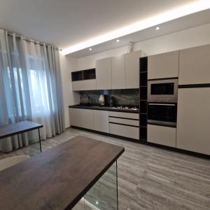 una cucina con armadi bianchi e un tavolo di House 21 Residence Room a Collecchio Altre 37 foto