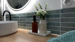 a bathroom with a vase of flowers and a sink at L'entracte, T2 rénové ! Jardin, Parking et Fibre in Pau +12 photos
