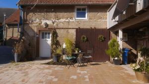 a patio with a table in front of a house at Boutique Ferienwohnung Schwalbenstall Uissigheim in Uissigheim