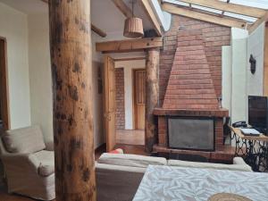 a living room with a brick fireplace and a couch at Casona La Recoleta in Cusco