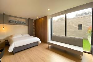 a bedroom with a bed and a large window at Domus Suites Chia in Chía