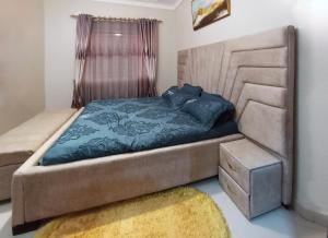a bedroom with a large bed with a blue comforter at Doreens Villa in Wakiso