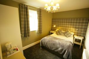 a small bedroom with a bed and a window at The Sunningdale in Bamburgh