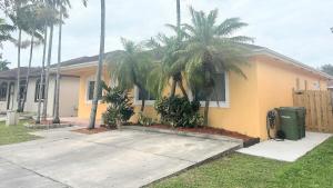 a house with palm trees in front of it at Homestead Green retreat in Homestead