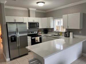 a kitchen with a stainless steel refrigerator and white cabinets at Homestead Green retreat in Homestead