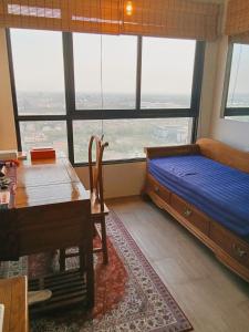 a bedroom with a bed and a desk and a table at One bedroom condo with rooftop pool in Ban Talat Rangsit +33 photos