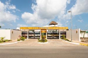 un grande edificio bianco con tetto giallo di Casa Palancar with beautiful swimming pool and private palapa a Cozumel