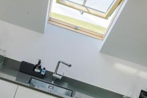 a kitchen with a sink and a window at Cobstone Cottage in Walmersley +40 photos